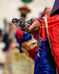 Vertical shot of a Tibetan Buddhist ritual dancer holding a skull idol