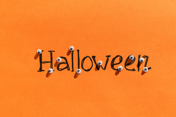 Halloween idea. The inscription halloween on an orange background on each letter of the eye. Festive background. Sinister background.