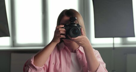 Young beautiful professional photographer taking picture with modern camera  indoors - Powered by Adobe