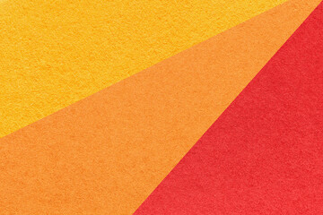 Old craft yellow, red and orange color paper background, macro. Structure of vintage abstract ginger cardboard