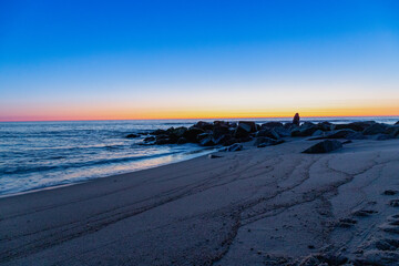 Blue hour on the beach with rocks in the water, long exposure