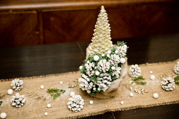 Winter Seasonal celebration. New Year festival. Hand made Christmas tree made from pine cone and spruce branches with linen background.