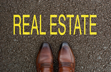 Top View of Business brown Shoes on the road with the text: real estate