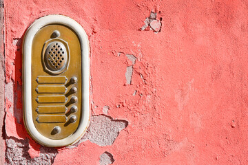 Old stone and brass bell system against a colored plaster wall - image with copy space