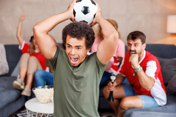 Football fans watching the game, cheering and celebrating victory