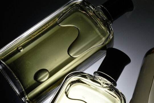 transparent jars with perfume lie on a light background. Close-up