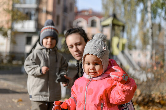 A young mother with a little daughter and son on a walk
