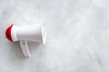 White megaphone against the empty wall. Hiring or advertising concept