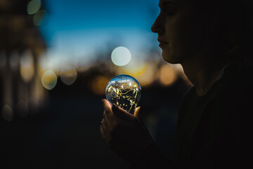 young worried woman holding bright shining lightbulb in her hands feeling unsave while in fear...