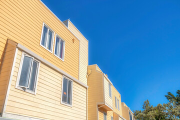 Low angle view of an apartment building with casement windows and wood lap siding in San Francisco