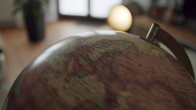 Tight shot of a vintage globe spinning in a modern living room setting.