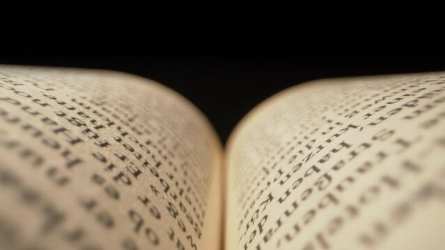 Moody macro shot pulling through the pages of a book with a dimming light above. A story coming to an end.