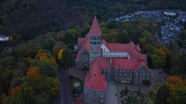 Aerial drone Shot of Abbey in Clervaux, Luxembourg in mystery evening twilight 