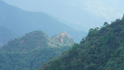 The beautiful mountains landscapes with the green forest and the erupted rock cliff as background...