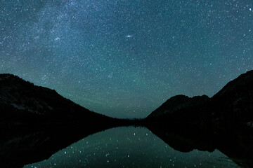 Toxaway Lake, gelegen in de Sawtooth Wilderness van Idaho, gezien op een zomernacht met veel sterren aan de hemel en weerspiegeld in het wateroppervlak.