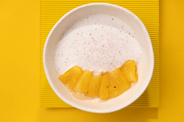 porridge with pineapple on a yellow background