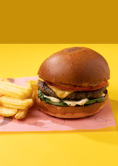 burger with french fries on a yellow background