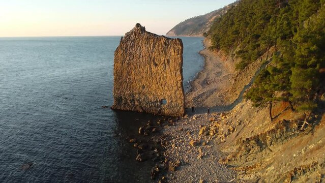 Lonely rock in the form of a wall on the seashore, drone flight