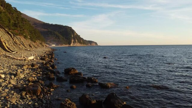 Coastline of rocky shore and blue sea, drone flight