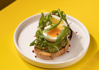 toast with egg and greens on a yellow background