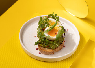 toast with egg and greens on a yellow background