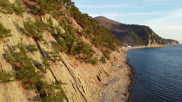 Coastline of rocky shore and blue sea, drone flight