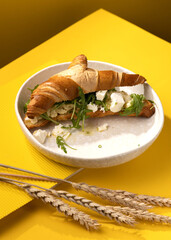 croissant with egg on a yellow background