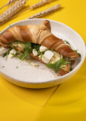 croissant with egg on a yellow background