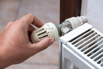 The hand that closes the radiator valve of the boiler in Europe, where there is a shortage of...