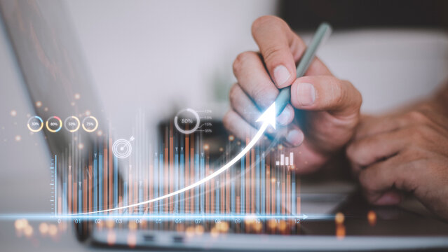 people using tablets And using his finger to touch the screen With a business graph showing up in a virtual screen.New startup ideas and business growth concept.