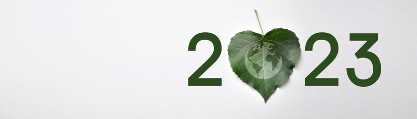 inscription: 2023 with the image of a plant leaf. A symbol of environmental protection in the new...