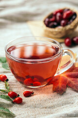 A cup of rose hip tea with fresh berries in a glass cup. Vintage background, selective focus