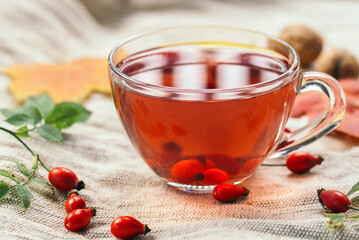 A cup of rose hip tea with fresh berries in a glass cup. Vintage background, selective focus