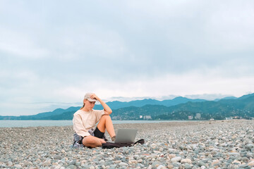 Remote work.Girl freelancer works remotely on the sea shore. workation, remote work,WFVH,Van Life vibes work from vacation home,work travel,remotely work.Travelling.Work from vacation remotely