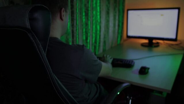 Man using mouse and keyboard types query in search engine on browser of personal computer. Online purchases in internet. Network web. Digital cyberspace. Guy is sitting in chair at home at night