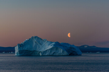 Beautiful moonrise in Greenland. Iceberg at sea. © Alexey Seafarer