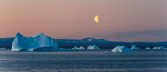 Beautiful moonrise in Greenland. Iceberg at sea. © Alexey Seafarer
