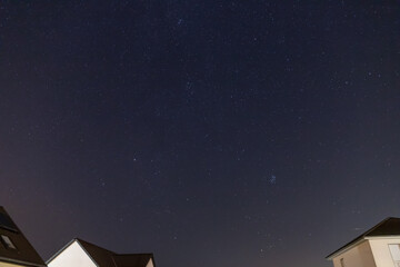 Starry sky over a housing settlement with meteorites (Perseids in August)