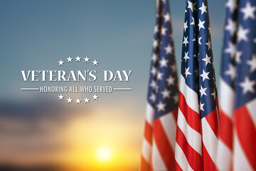 American flags with Text Veterans Day Honoring All Who Served on sunset background. American holiday banner.