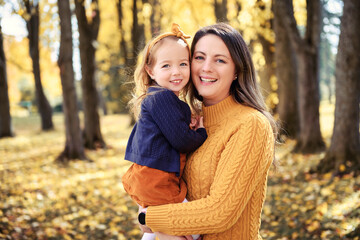 Fototapeta premium Mother and daughter in the Park and enjoying the beautiful autumn nature.