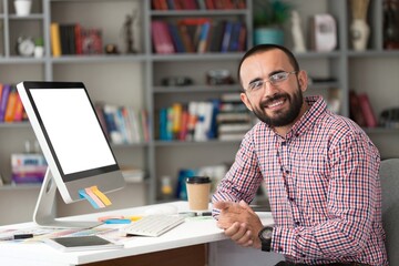 Bearded businessman working on laptop in office.   Video online webinar.