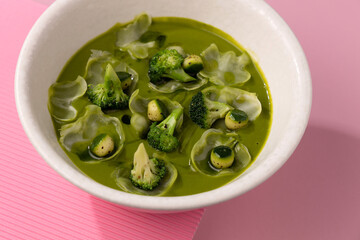 cream broccoli soup on a pink background
