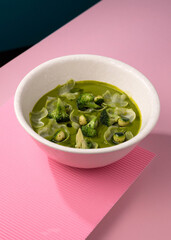 cream broccoli soup on a pink background