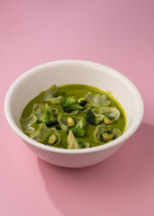 cream broccoli soup on a pink background