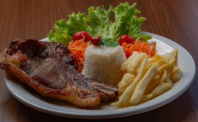 Filet with fries, served with rice and lettuce, tomato and carrot salad