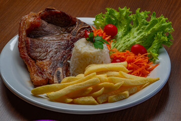 Filet with fries, served with rice and lettuce, tomato and carrot salad