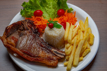 Filet with fries, served with rice and lettuce, tomato and carrot salad