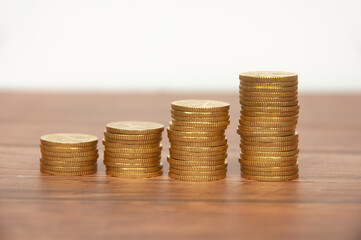 Golden coins stacked on wooden table. Wealth and business growth concept.