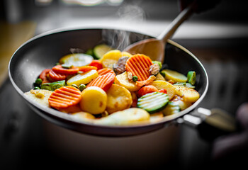 cooking tasty vegetable mix in pan on kitchen