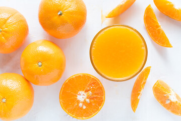 Fresh orange juice in the glass with orange fruit on wood background from top view